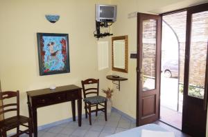 a room with a desk and chairs and a television at Casa Matarazzo in Lipari