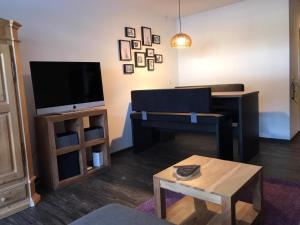 a living room with a flat screen tv and a table at Derby 25 in Arosa