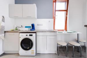 ジェールにあるGold Apartment - Győrの白いキッチン(洗濯機、テーブル付)