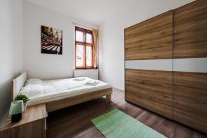 ジェールにあるGold Apartment - Győrのベッドルーム1室(ベッド1台付)、大きなスライドドアが備わります。