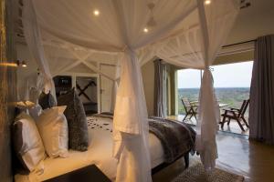 a bedroom with a canopy bed with a view at isiLimela Game Lodge in Hoedspruit