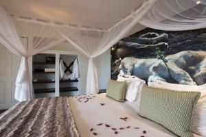 a bedroom with a bed with a mural of elephants at isiLimela Game Lodge in Hoedspruit