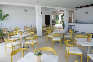 an empty restaurant with tables and yellow chairs at CUBE Baler in Baler