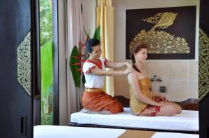 een vrouw die haar haar laat knippen door een kapper bij Suuko Wellness & Spa Resort in Chalong 