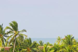 a view of the ocean from a resort with palm trees at Supun Villa in Bentota