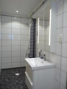 La salle de bains blanche est pourvue d'un lavabo et d'un miroir. dans l'établissement Holiday home Hammarstrand 4 persons, à Hammarstrand