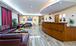 a woman standing at a bar in a hotel lobby at Nefeli Hotel in Chania Town