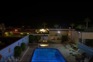 a house with a swimming pool at night at Americas Best Value Inn and Suites -Yucca Valley in Yucca Valley