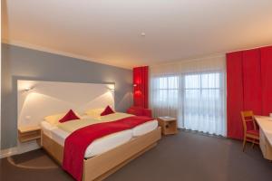 ein Schlafzimmer mit einem großen Bett und einem roten Vorhang in der Unterkunft Alpenresidenz Buchenhöhe in Berchtesgaden
