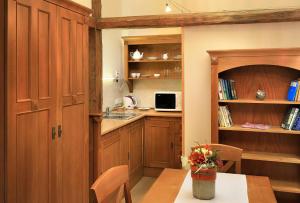 a kitchen with wooden cabinets and a table with flowers at Castle View Apartments in Český Krumlov