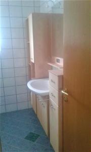 Apartment MASCH في Arriach: حمام مع حوض أبيض ومرآة