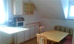 a small kitchen with a table and a microwave at Apartment MASCH in Arriach