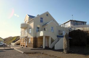 a large white building with stairs leading up to it at Hvammur Apartments in Höfn