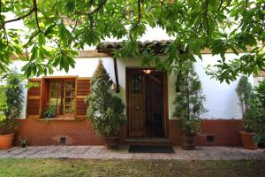 uma casa com uma porta castanha e algumas plantas em El Berdial em San Esteban de Pravia