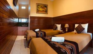 Cette chambre comprend deux lits et une salle de bains. dans l'établissement Taman Homestay, à Nusa Lembongan