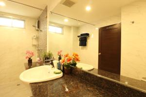 een badkamer met een wastafel en een spiegel bij Serena Sathorn Suites in Bangkok +108 foto's