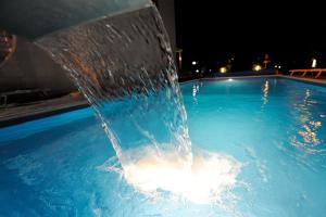 a water fountain in a swimming pool at night at Hotel Life in Rimini