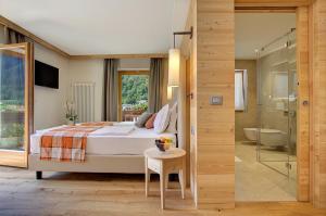 una camera con letto e un bagno con doccia di Active Hotel Monte Giner a Mezzana