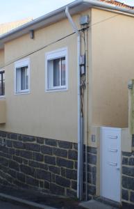 una casa con un muro di mattoni e una porta bianca di Al Gaia Centro Historico a Vila Nova de Gaia