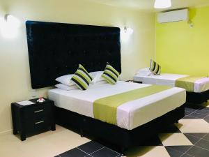 a bedroom with two beds and a black headboard at Moatoga Hotel in Apia