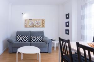 a living room with a couch and a table at Livemalaga Ventura & Parking in Málaga