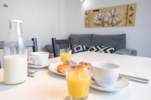 a table with plates of food and two glasses of orange juice at Livemalaga Ventura & Parking in Málaga