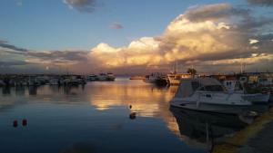a group of boats docked in a harbor with a cloudy sky at Crystal Home near Airport in Artemida +13 photos