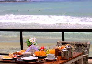 - une table avec de la nourriture et une vue sur la plage dans l'établissement Namoa Pousada, à Cabo de Santo Agostinho