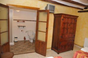 a bathroom with a toilet and a tv on the wall at Casa Rural "La Bardena Blanca I " in Arguedas