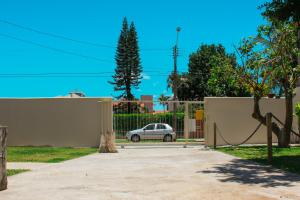une voiture garée devant une clôture avec allée dans l'établissement Recanto Dos Coqueiros, à Florianópolis
