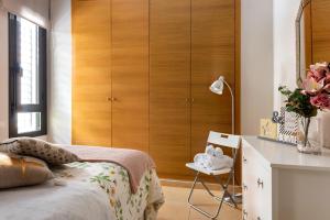 セビリアにあるHSH Suites Metropolのベッドルーム1室(ベッド1台付)、木製キャビネットが備わります。