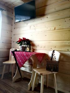 a table and chairs in a room with a wooden wall at Pokoje goscinne u Jozka in Chochołów