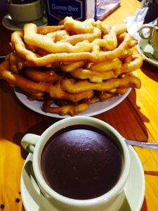 a plate of onion rings next to a cup of coffee at Camping Laciana Natura in Villablino