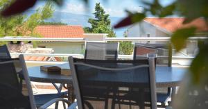 Ein Tisch und Stühle auf einem Balkon mit Blick auf ein Haus in der Unterkunft Apartmani Cesarec in Basina + 32 Fotos