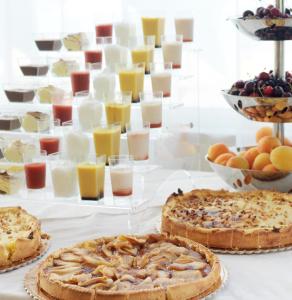 three pies on a table with glasses of orange juice at Hotel Life in Rimini