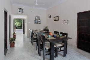 a dining room with a long table and chairs at Mimosa Udaipur in Udaipur