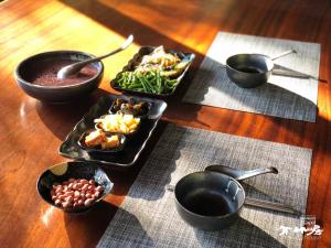 einen Tisch mit Teller mit Lebensmitteln und Schüsseln mit Lebensmitteln in der Unterkunft Bamboo House in Zhushan