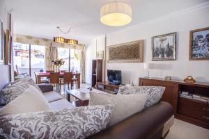 ein Wohnzimmer mit einem Sofa und einem TV in der Unterkunft Junto a la casa natal de Picasso in Málaga