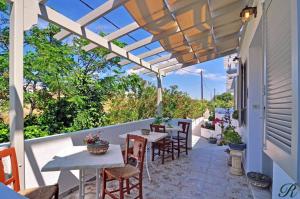 patio con tavoli e sedie sotto un pergolato di Hotel Rigas ad Adámas