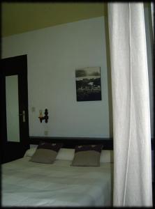 - une chambre avec un lit, un miroir et des rideaux dans l'établissement Auberge MAS DE LAYALLE, à Saintes-Maries-de-la-Mer