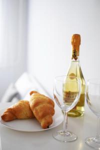 a plate of croissants and a bottle of wine at White Almond Apartment in Budapest