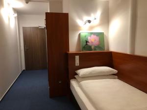 a bedroom with a bed and a flower painting on the wall at Hotel Mirabell in Erlangen