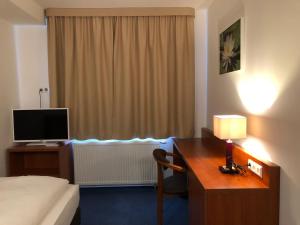 a hotel room with a bed and a desk with a computer at Hotel Mirabell in Erlangen