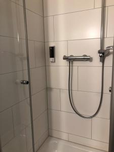 La salle de bains est pourvue d'une douche avec une porte en verre. dans l'établissement Hotel Mirabell, à Erlangen