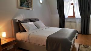 a bedroom with a bed and a window at Apartment Cobanija in Sarajevo