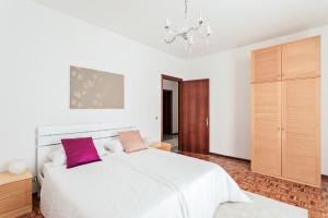 a bedroom with a white bed with two pink pillows at Villa Diana Tarzo in Tarzo
