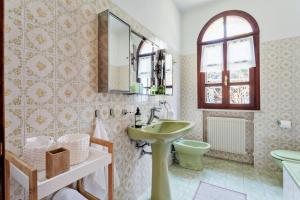 a bathroom with a sink and a toilet and a mirror at Villa Diana Tarzo in Tarzo +27 photos