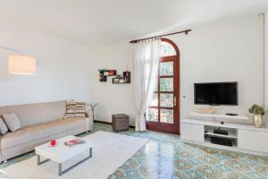 a white living room with a couch and a tv at Villa Diana Tarzo in Tarzo
