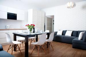 una cucina e un soggiorno con un tavolo e un divano di Apartament IKAR - 2 pokojowy przy morzu z własnym ogródkiem a Pobierowo