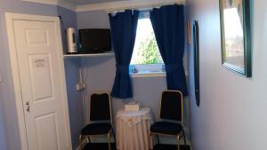 a room with two chairs and a table and a window at Sunnyside B&B in Balloch